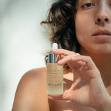 WYLYS Double Rose Luminizer Bottle held by Woman When You Love Your Skin