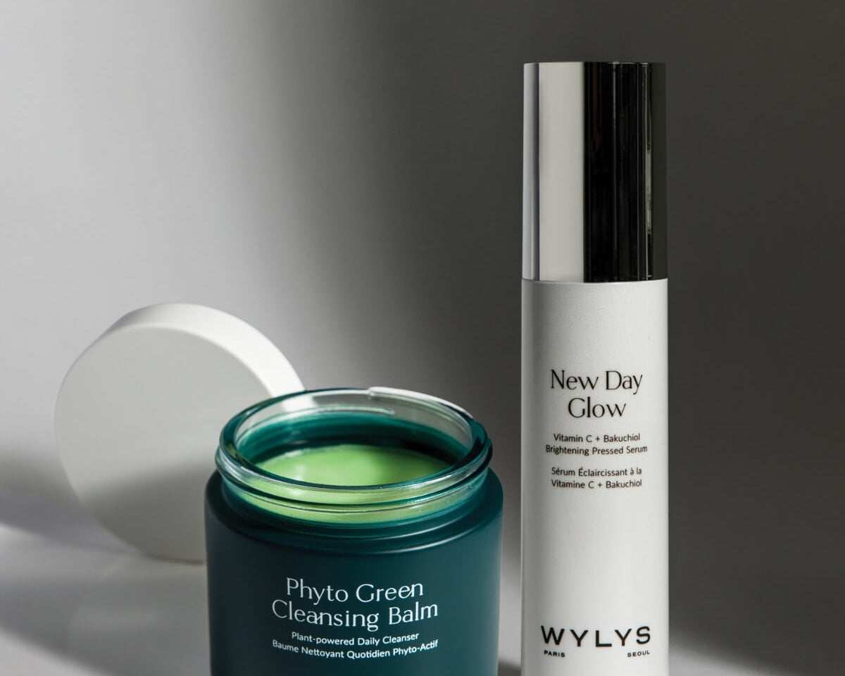 WYLYS Phyto Green Cleansing Balm and New Day Glow Brightening Pressed Serum on a white surface with shadows.