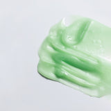 Texture shot of WYLYS Phyto Green Cleansing Balm showing its semi-transparent green gel-to-oil consistency.