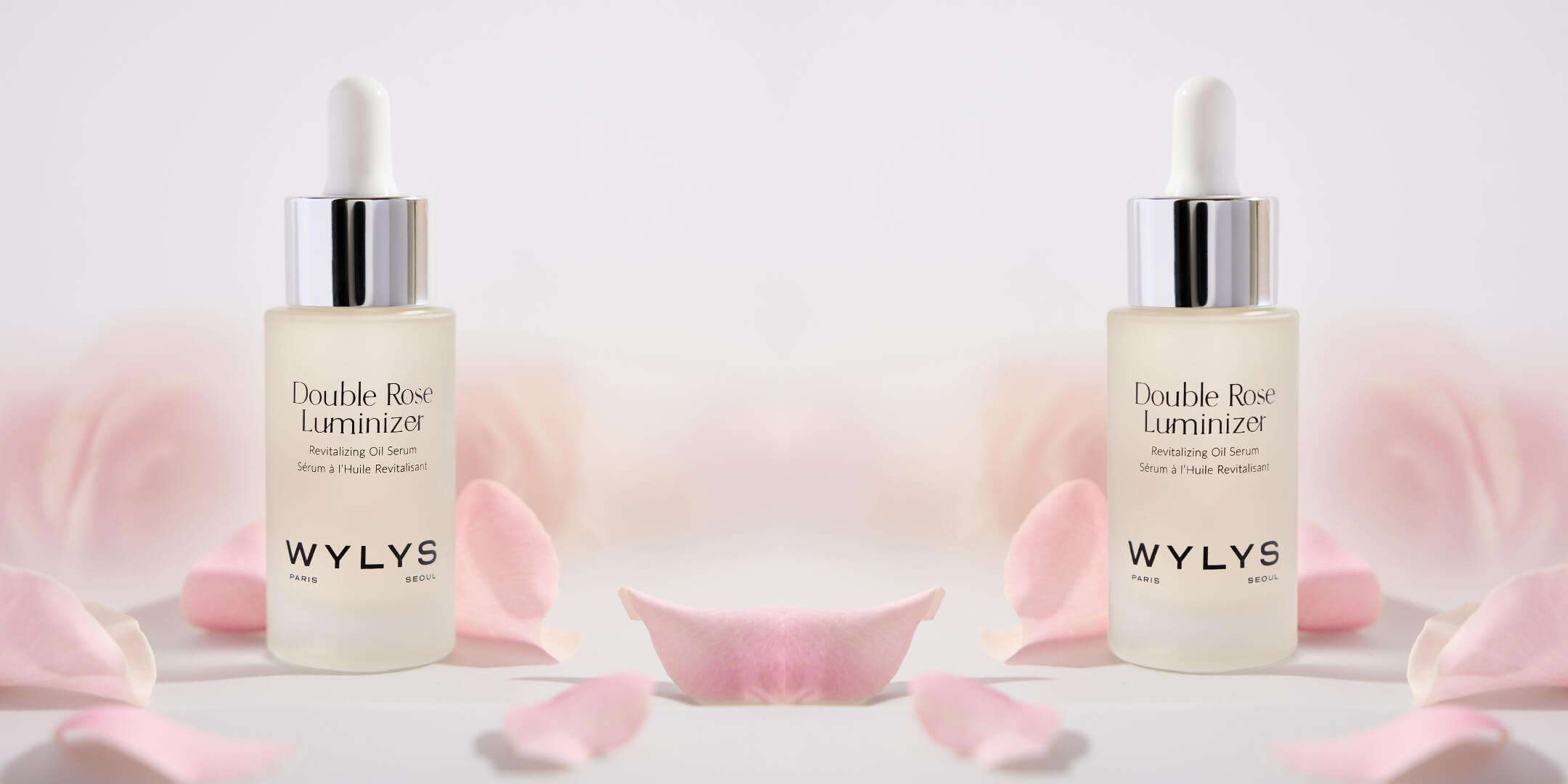 Two WYLYS Double Rose Luminizer bottles with pink petals on a light background
