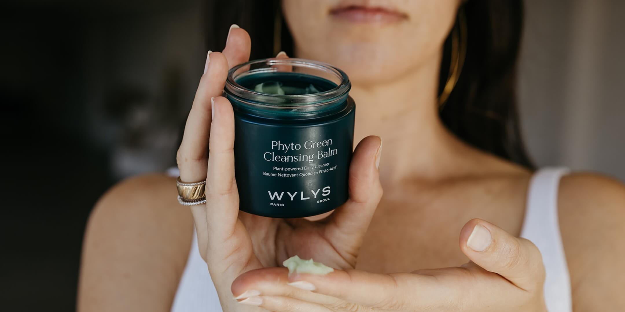 Person holding a WYLS Phyto Green Cleansing Balm with a blurred background